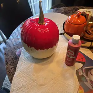 Paint the top half of Your Halloween Pokémon Ball pumpkin with red acrylic paint